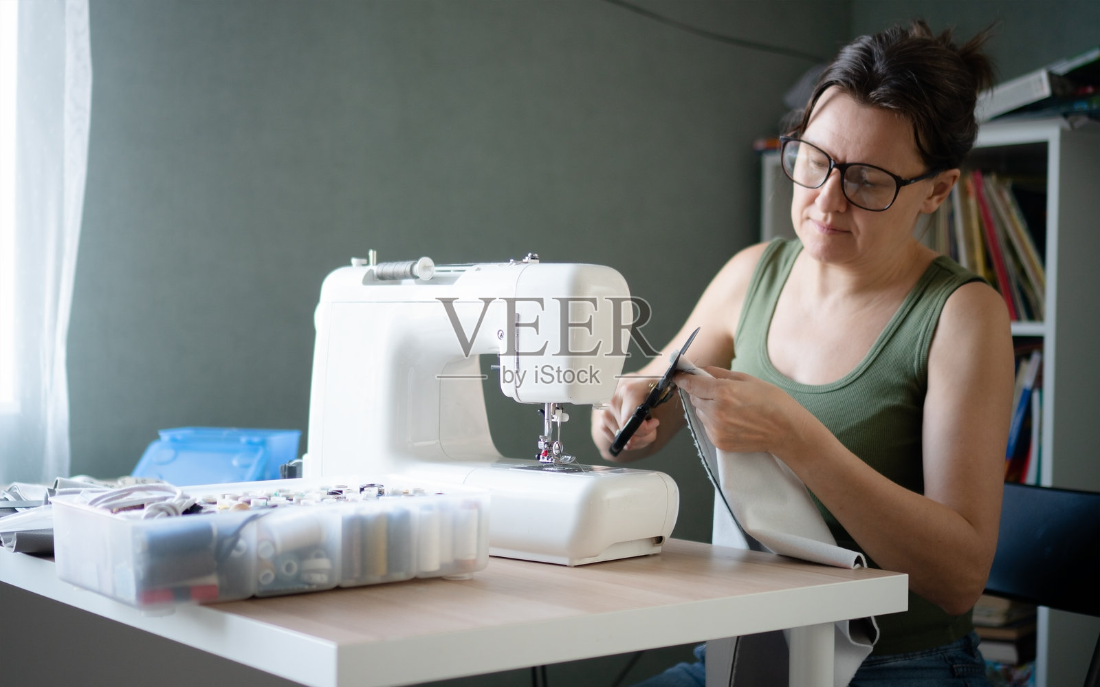 女子在工作室的缝纫机上缝纫照片摄影图片