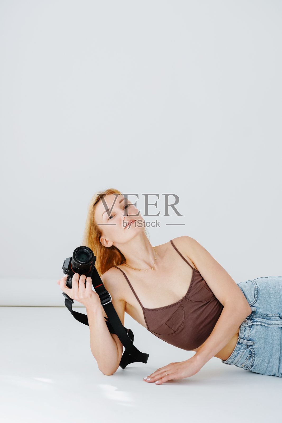 美丽的女性摄影师，手持数码相机，极简风格的摄影作品。照片摄影图片