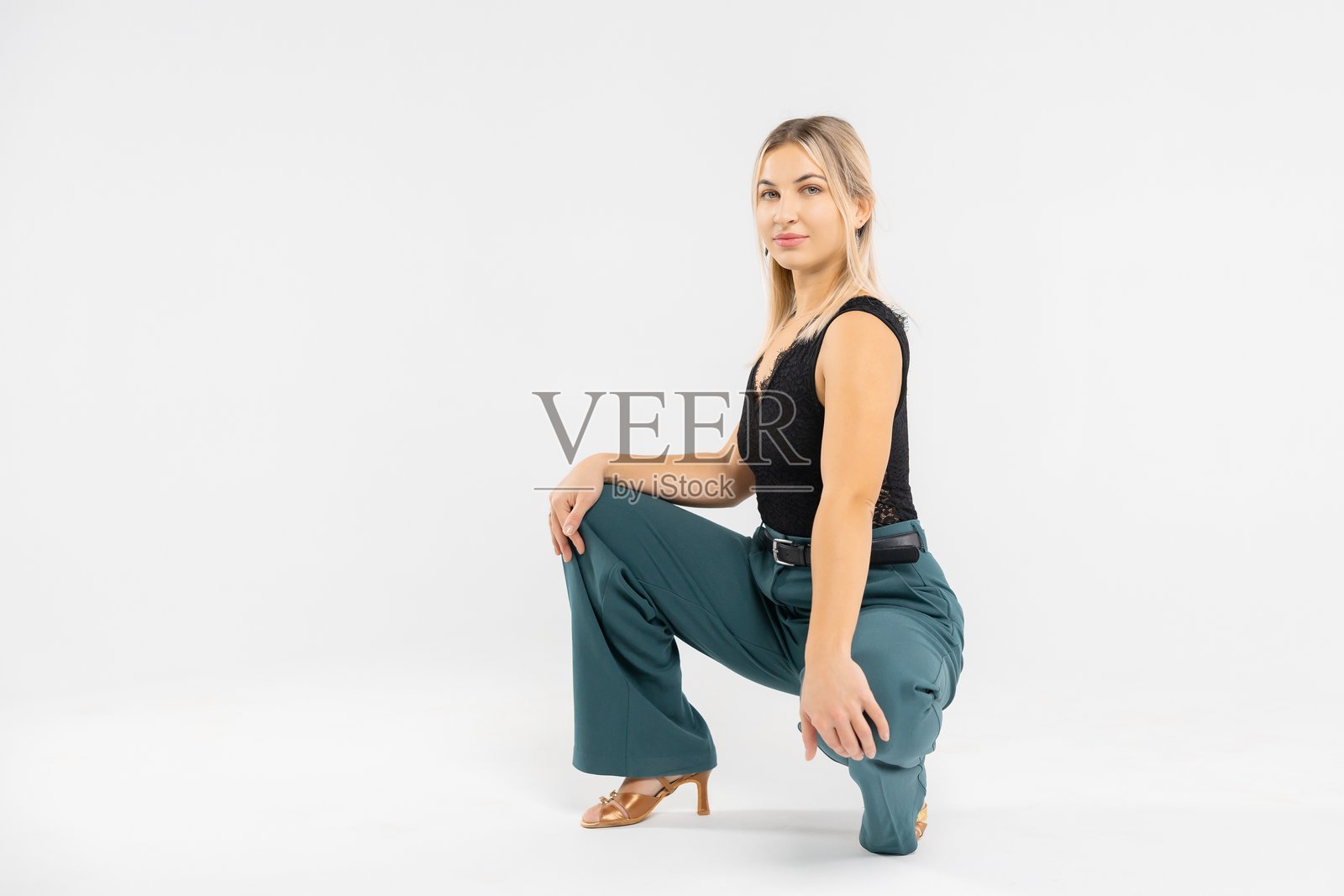 自信的女商人在工作室里蹲着，展示着现代的办公室着装照片摄影图片