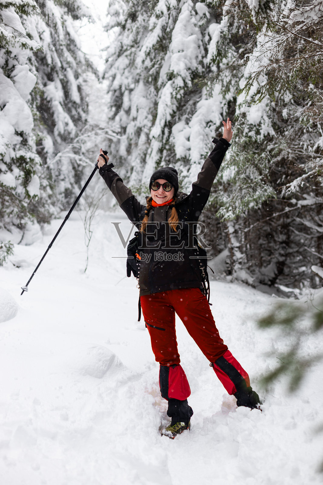 一位快乐的旅行者在雪林中进行一次充满冒险的冬季徒步，享受着大自然的美景照片摄影图片