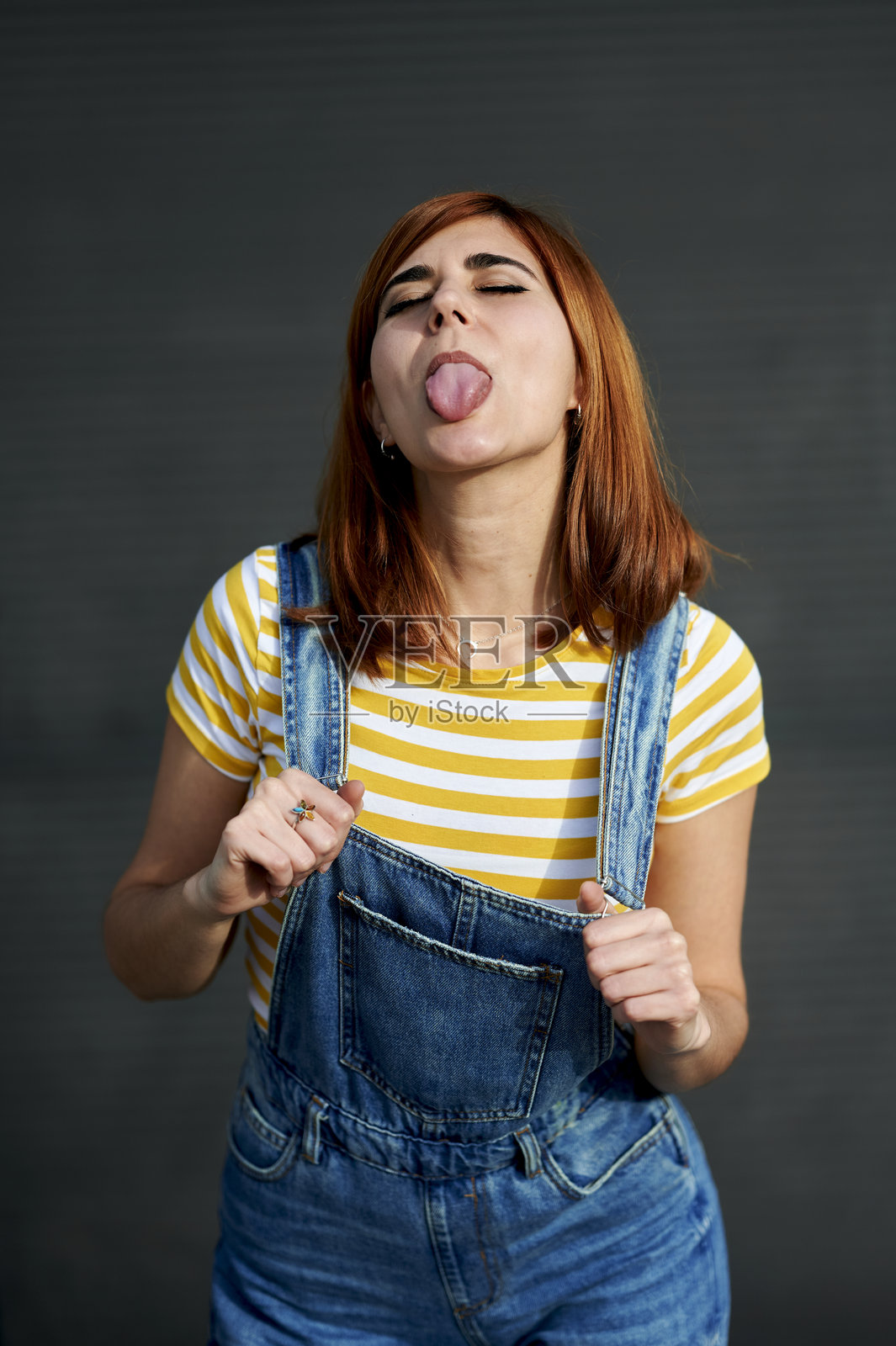 一位女士做鬼脸吐舌头照片摄影图片