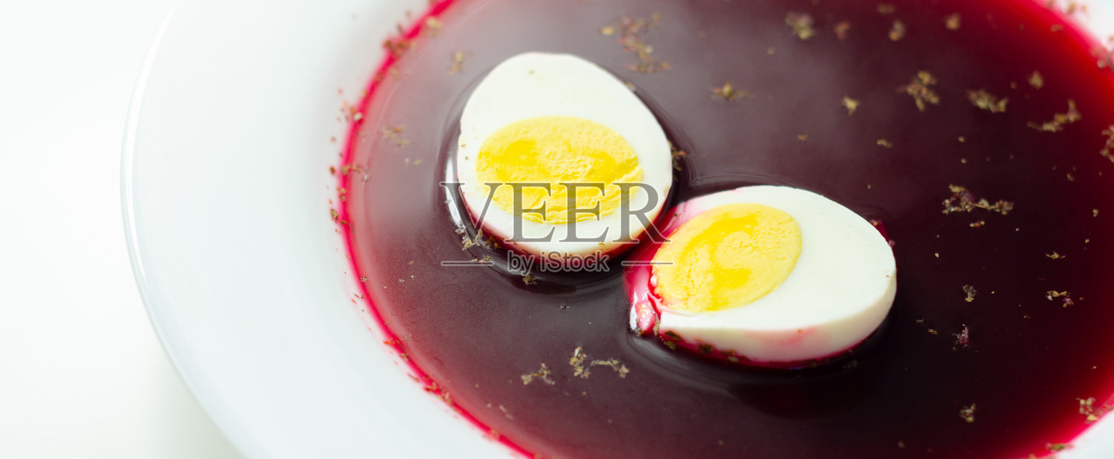 一碗红汤，里面有两颗鸡蛋照片摄影图片