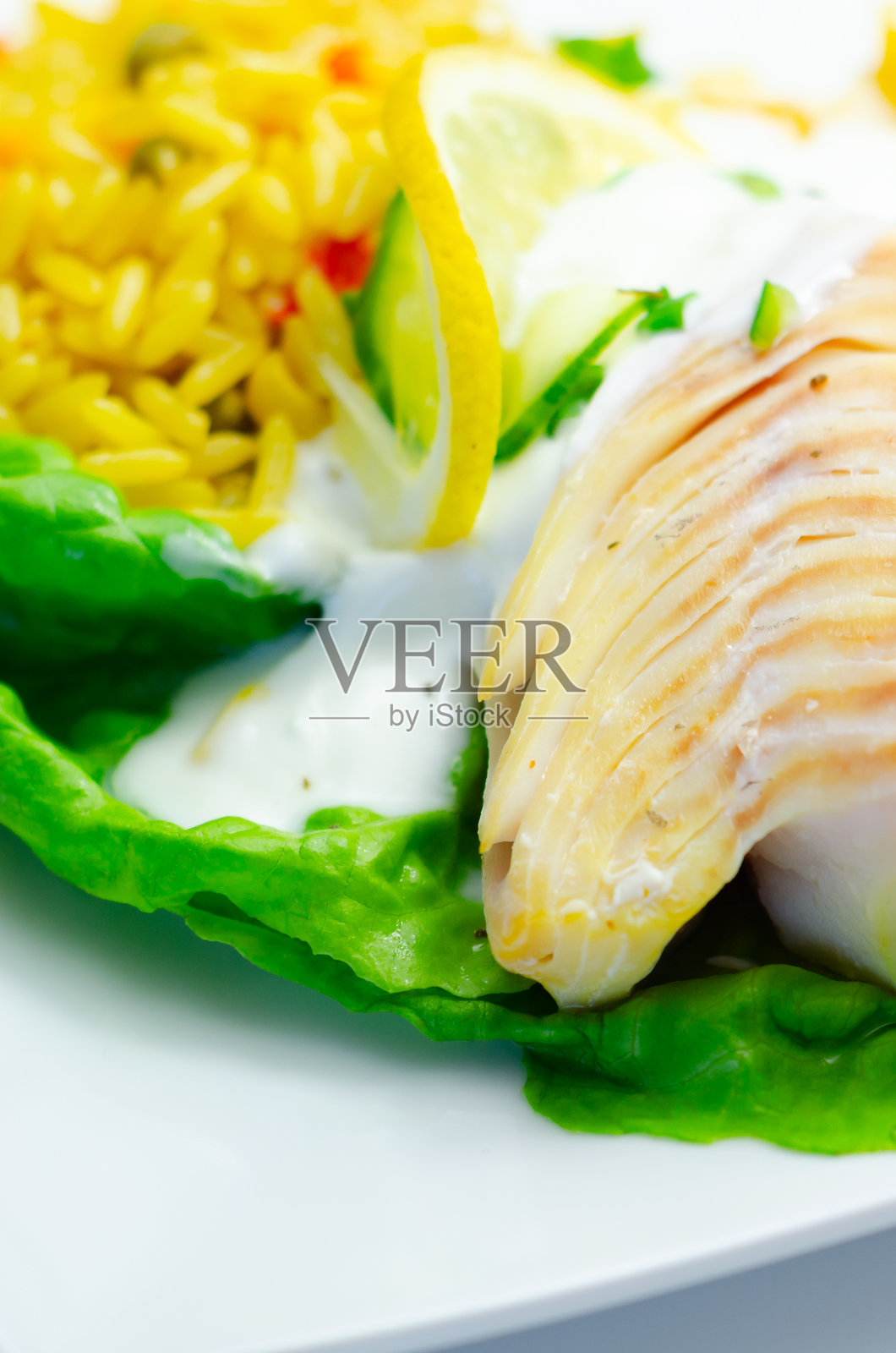 一份包含鱼排、米饭和柠檬片的食物拼盘照片摄影图片