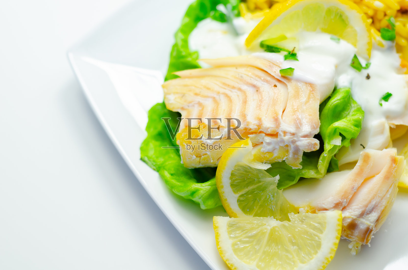 一份包含鱼柳、米饭和柠檬片的食物盘照片摄影图片