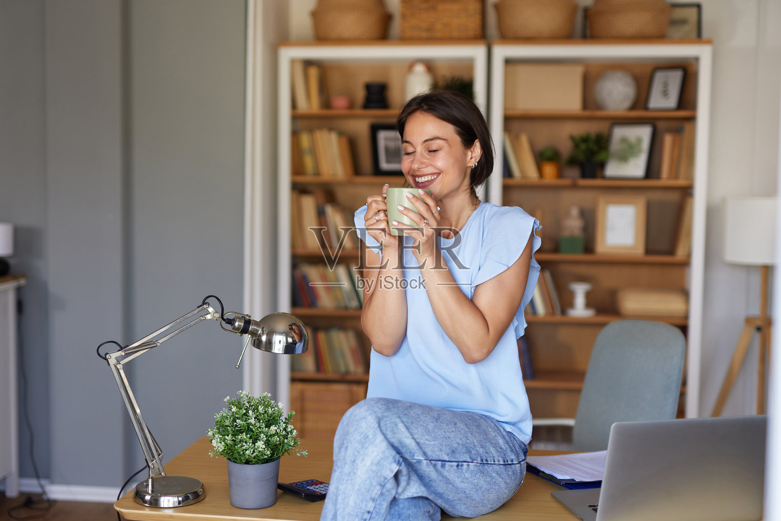 年轻女子在家中办公室工作时享受咖啡休息时间照片摄影图片