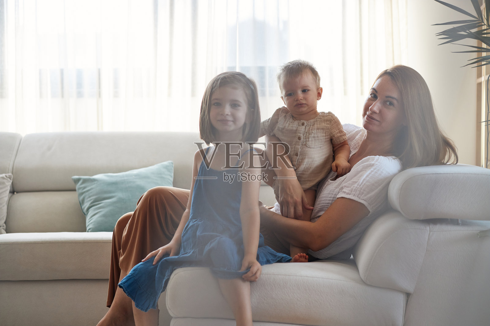 妈妈在家里的沙发上和孩子们一起放松照片摄影图片