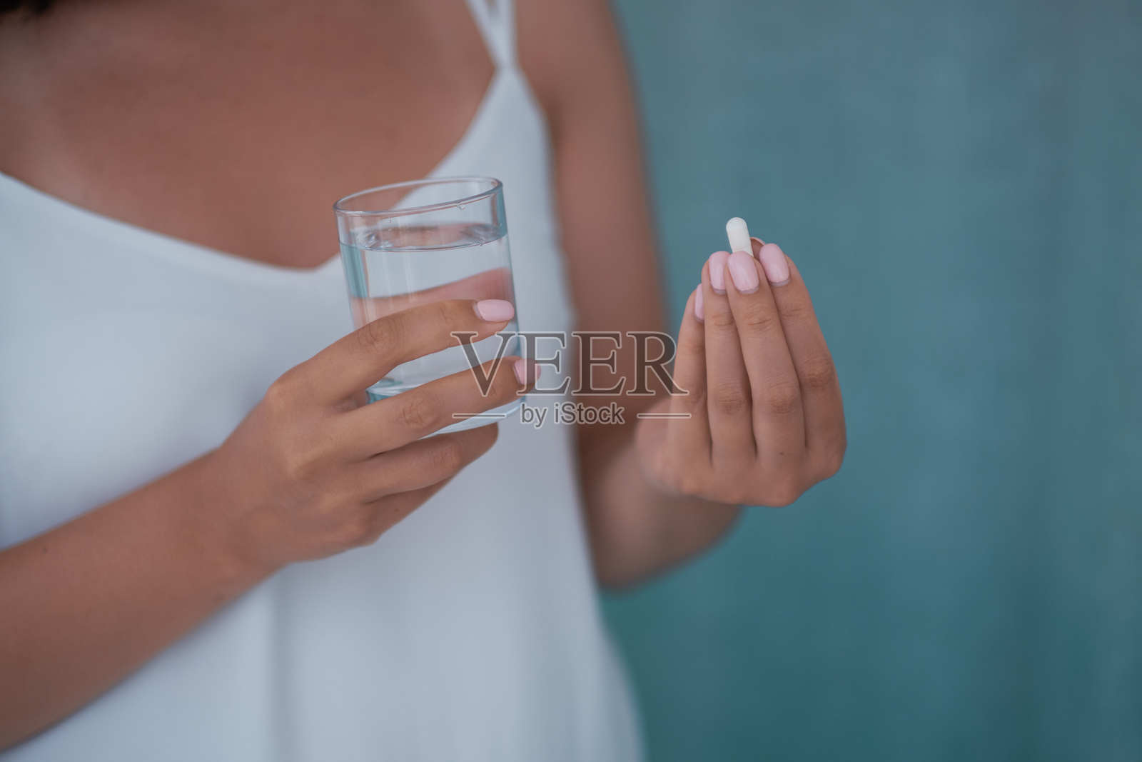 生病的女性正在服药，可能是抗抑郁药、止痛药或抗生素。年轻女性正在服用避孕药。药房和医疗保健概念照片摄影图片