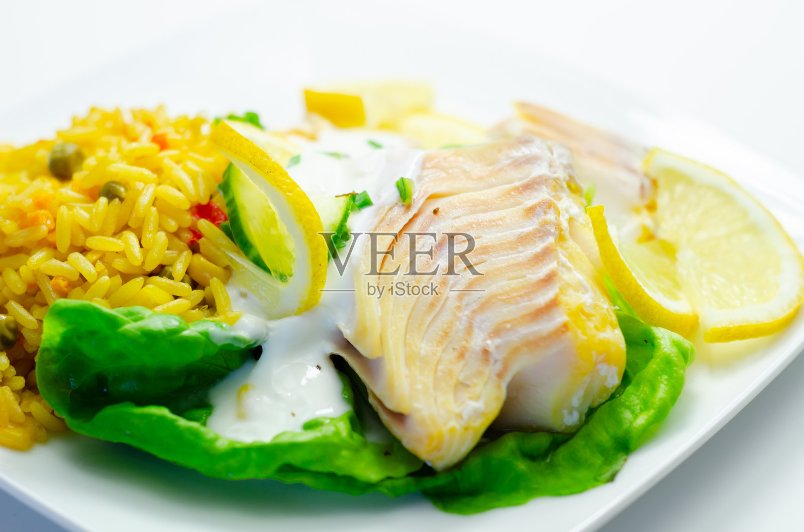 一份包含鱼片、米饭和柠檬片的食物拼盘照片摄影图片
