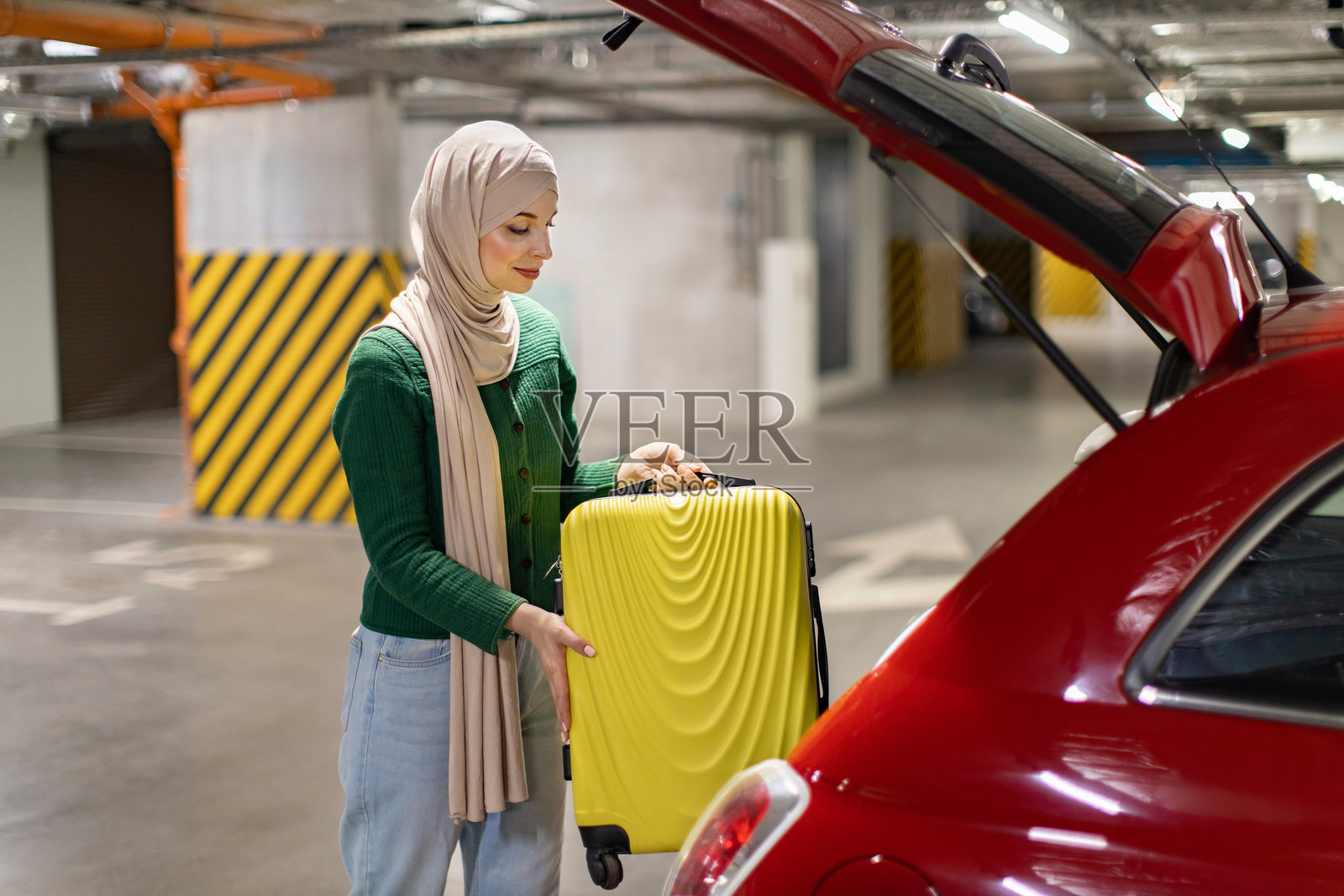 女人将行李箱装进汽车照片摄影图片