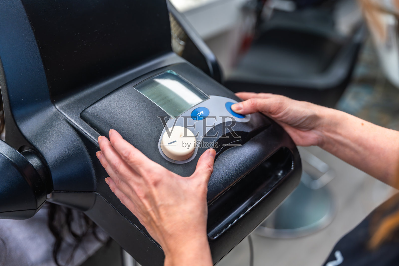 发型师在沙龙里为顾客调整专业的蒸汽焗油机进行护理照片摄影图片
