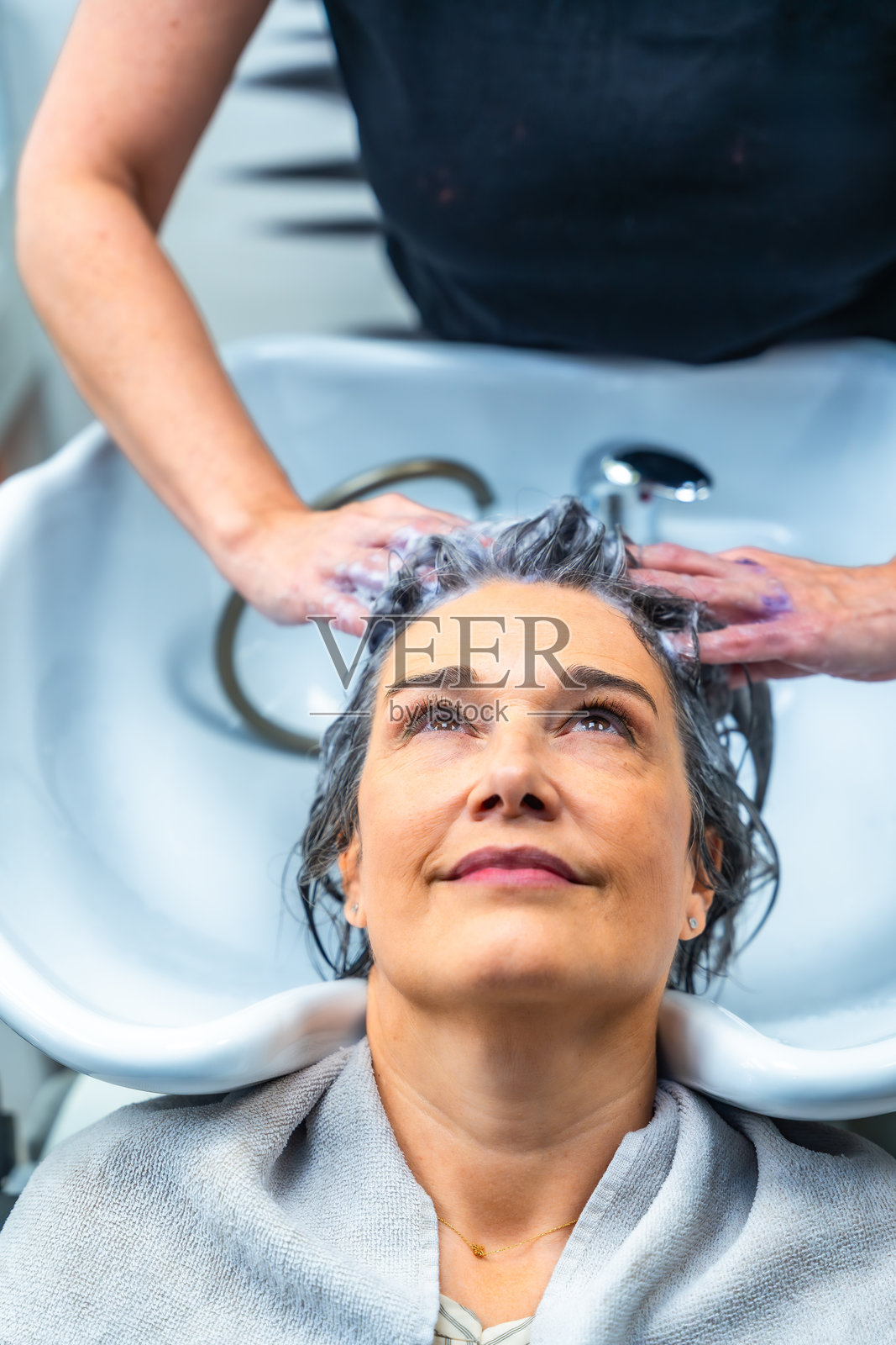 女性在沙龙接受洗发美容护理照片摄影图片
