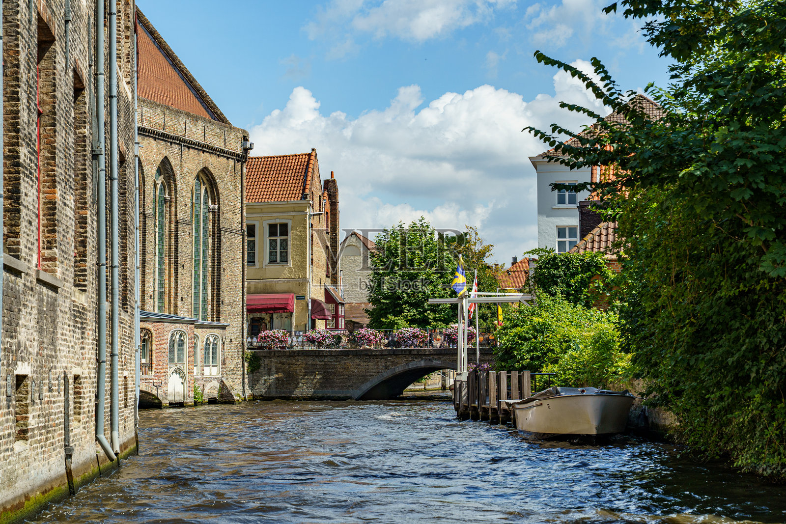 从布鲁日运河水面上看到的城市街景，堤岸两侧是色彩各异的房屋。照片摄影图片