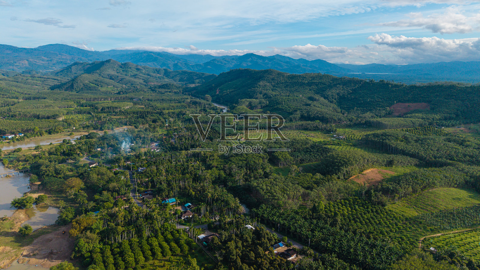 航拍热带绿色森林中的河流运河，伴着清晨的日出照片摄影图片