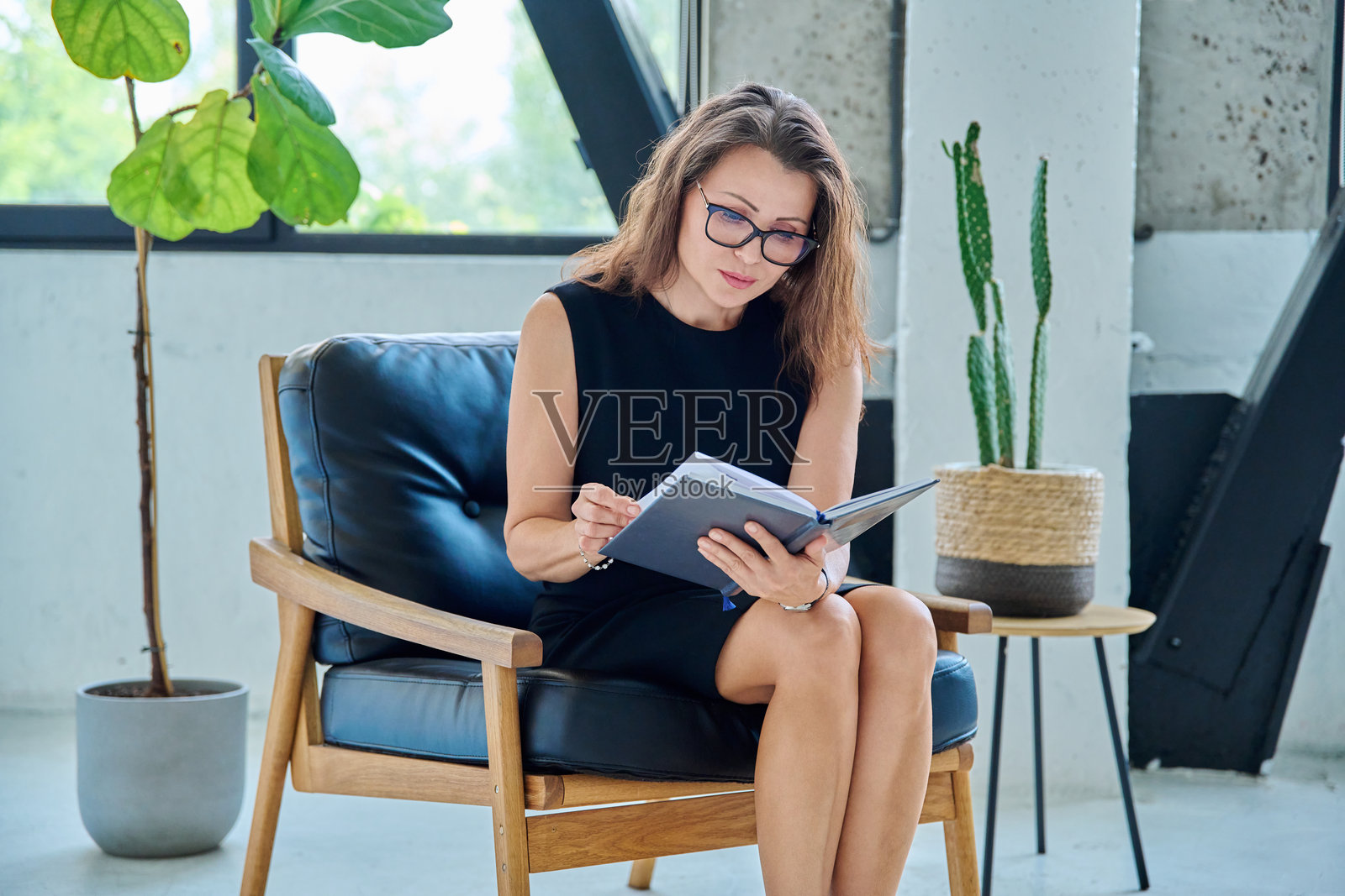 办公室里，一位女商人、心理学家或治疗师手持商务笔记本的肖像照片摄影图片