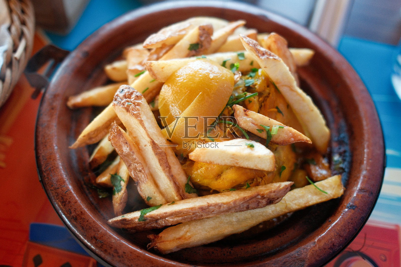 摩洛哥风味鸡肉塔吉锅配腌渍柠檬和炸薯条照片摄影图片