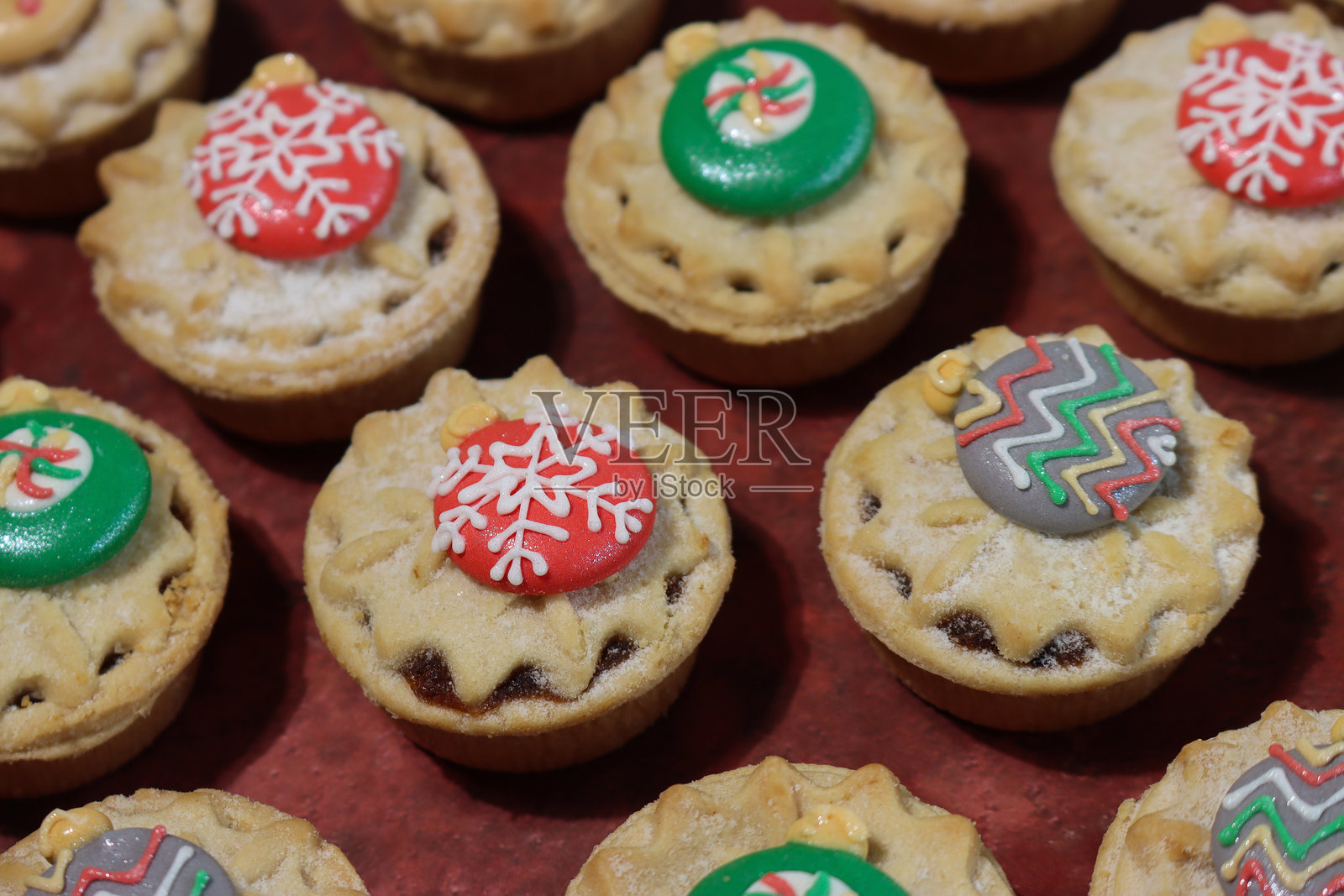 圣诞迷你肉馅饼和挞，带有糖霜顶部、装饰球和糖霜装饰/节日纸杯蛋糕和蛋糕照片摄影图片