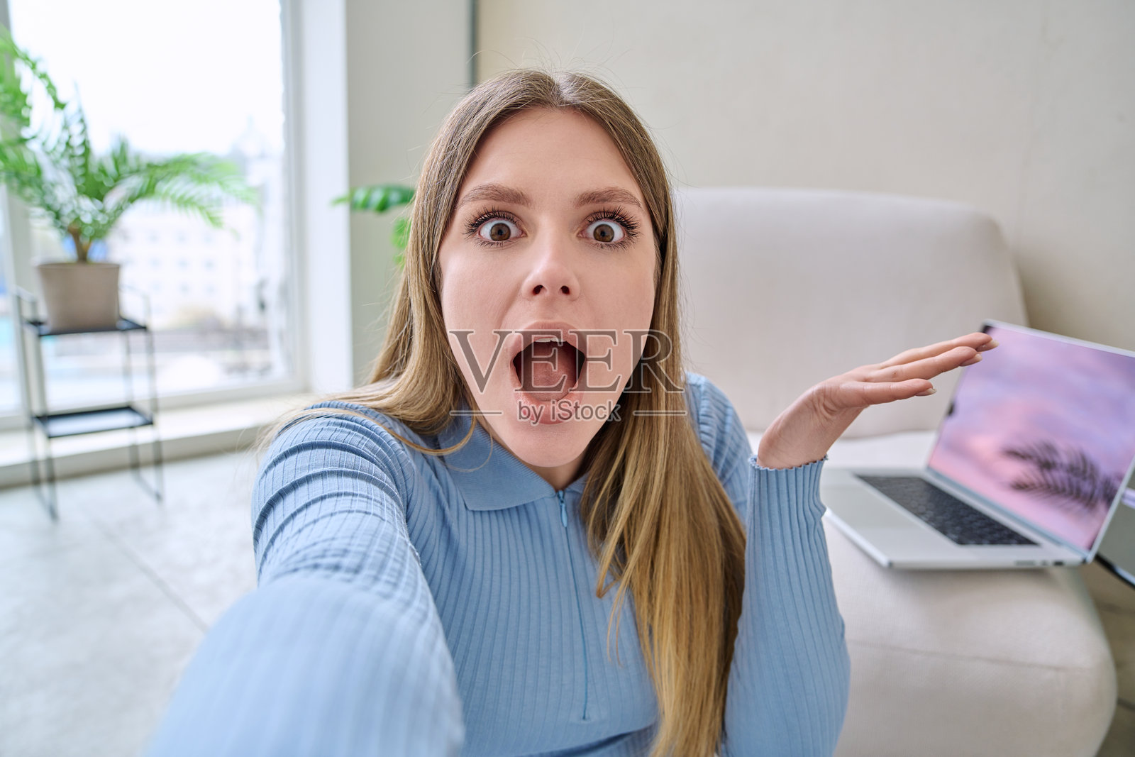 年轻女子在家中拍摄的惊喜震惊自拍肖像照片摄影图片