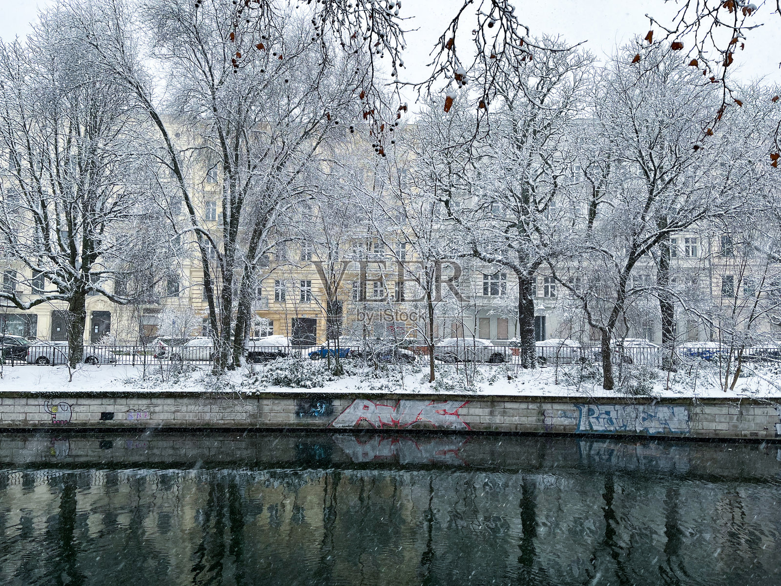 普拉努费尔街和兰德维克运河沿岸的建筑在雪中，周围有树木照片摄影图片