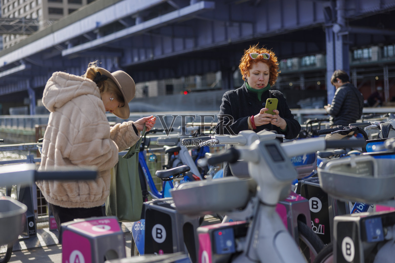 顾客在纽约市的站点使用智能手机租用花旗银行的电动自行车。照片摄影图片