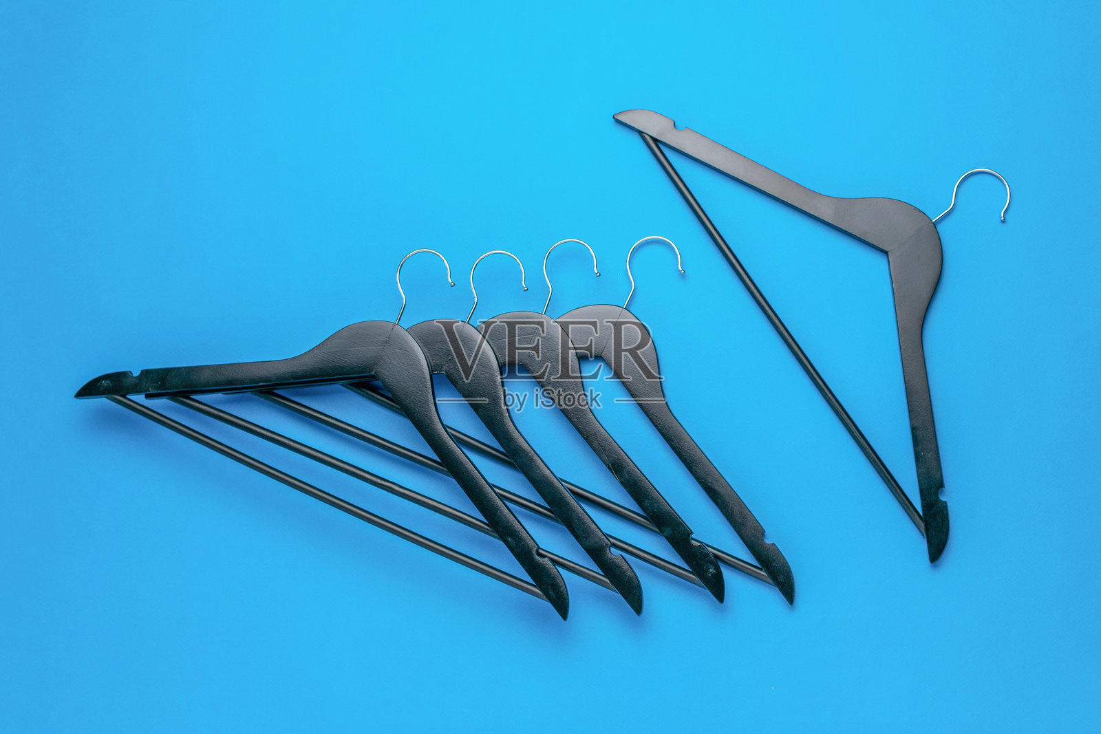 简约黑色衣架，背景为蓝色，体现现代收纳与风格照片摄影图片