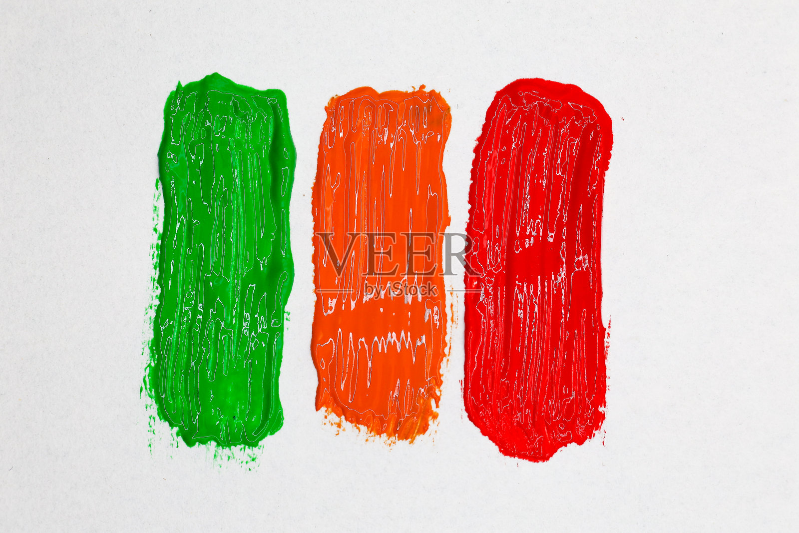 白底上绿色、橙色和红色的水彩画笔触，俯视角度照片摄影图片