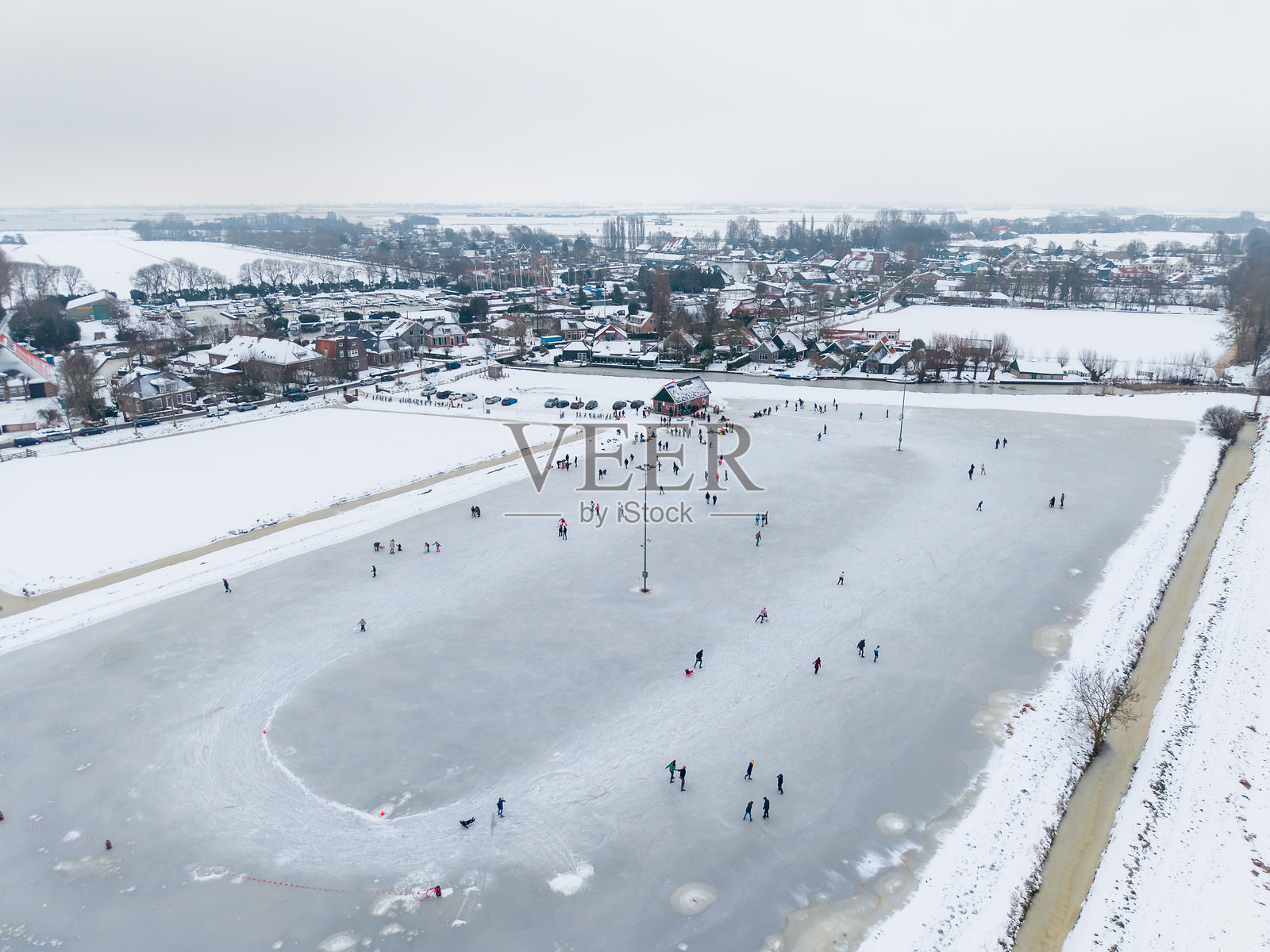 冬季，俯瞰人们在结冰的湖面上滑冰照片摄影图片