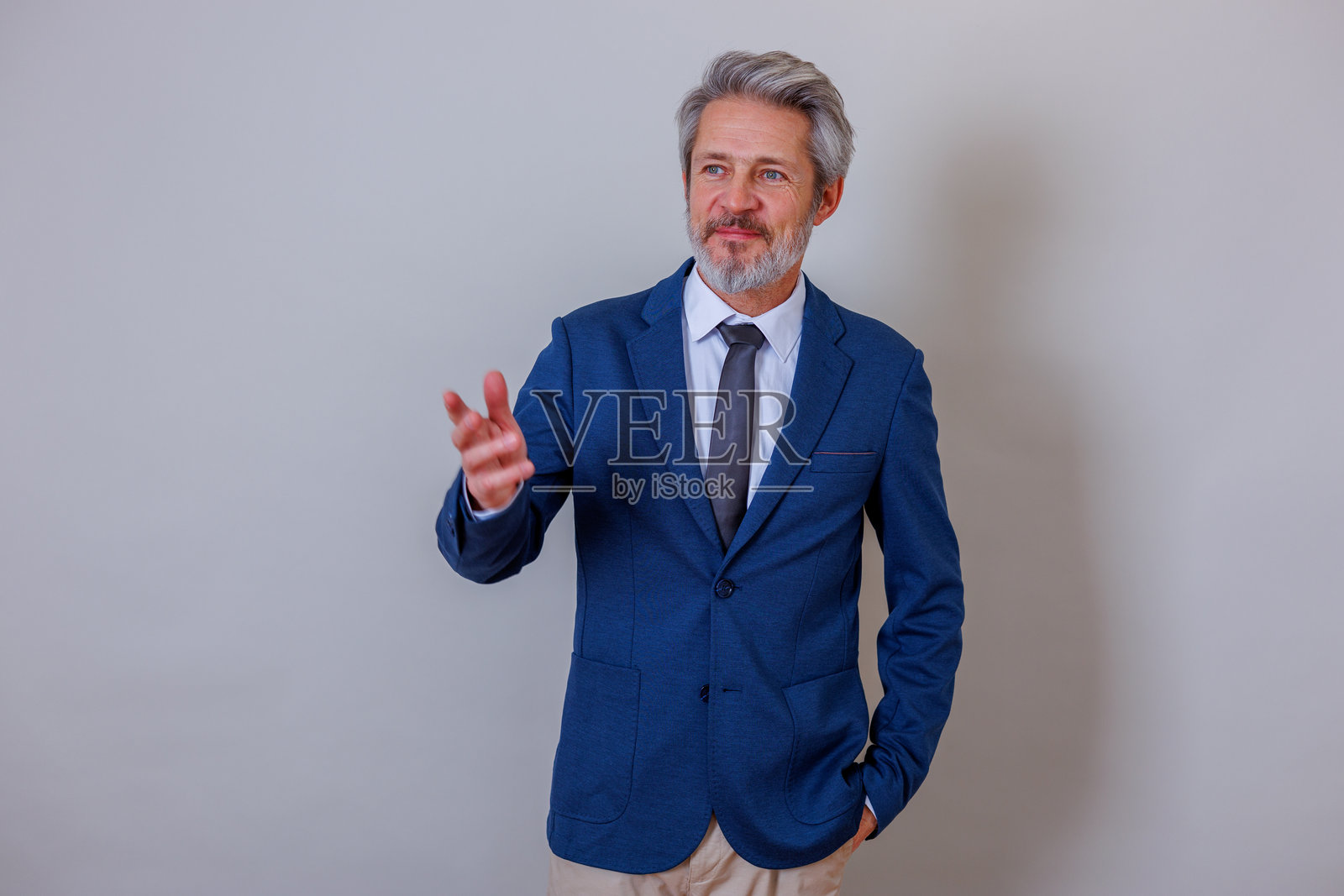 自信的商人微笑着，用手势在透明的墙壁背景前解释或展示想法照片摄影图片