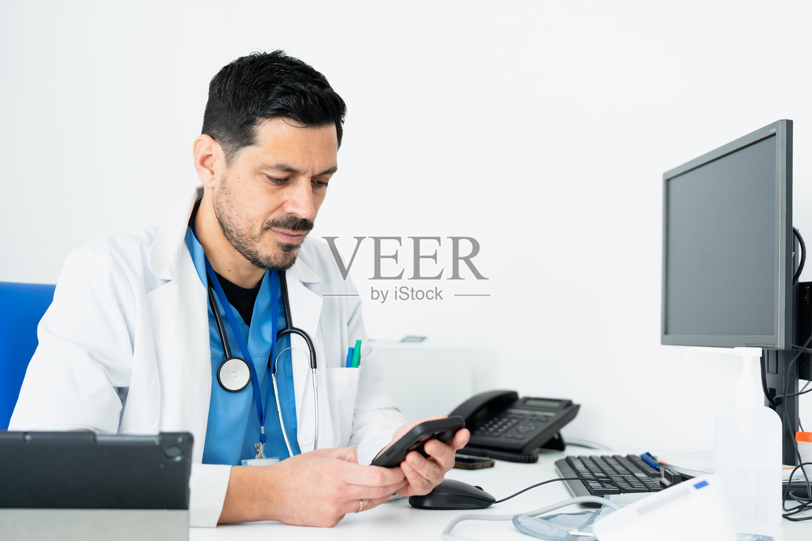 医生在诊室里查看智能手机照片摄影图片