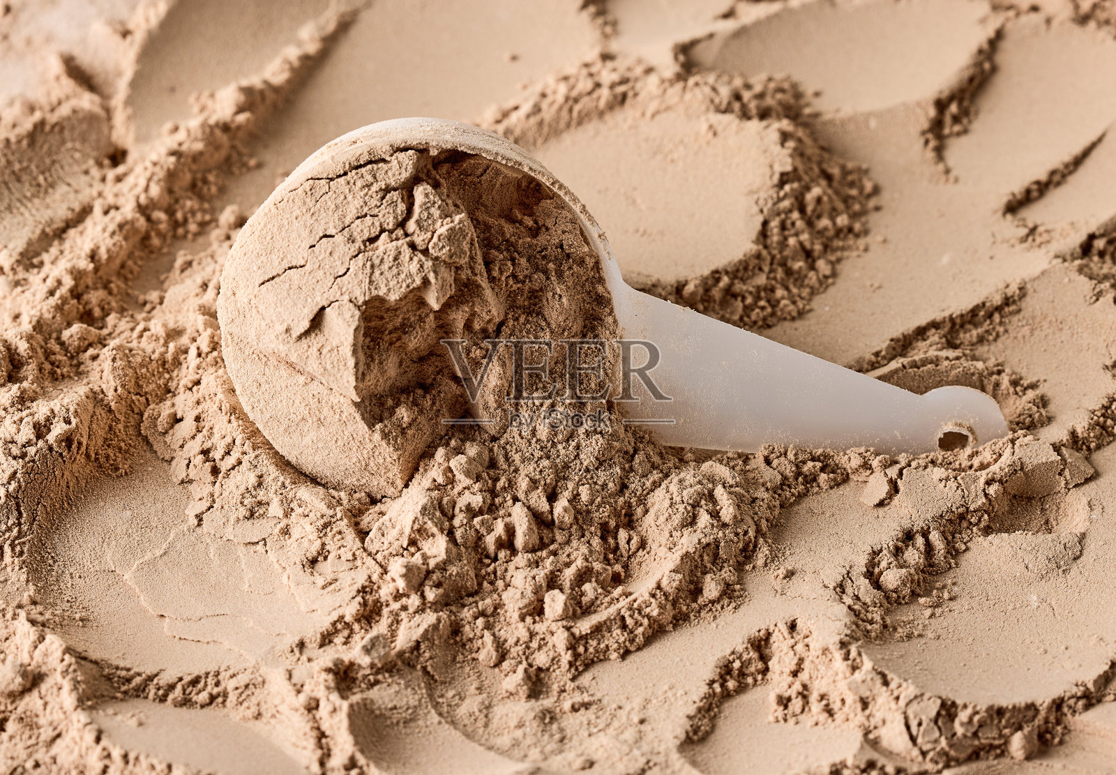 勺子里的蛋白粉。用于准备运动或膳食饮品的干粉混合物。照片摄影图片