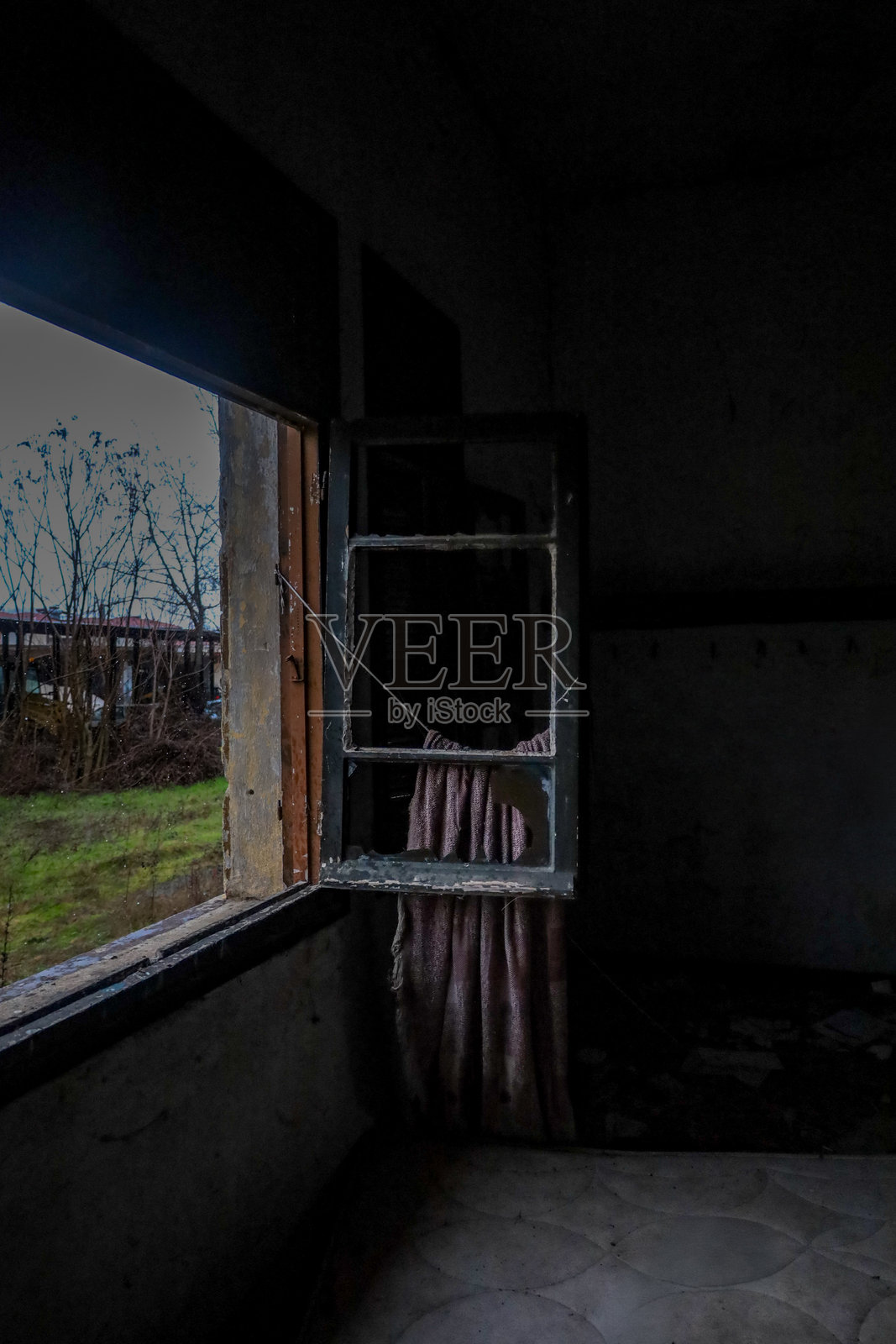 废弃房间里破损窗户上的破旧窗帘照片摄影图片