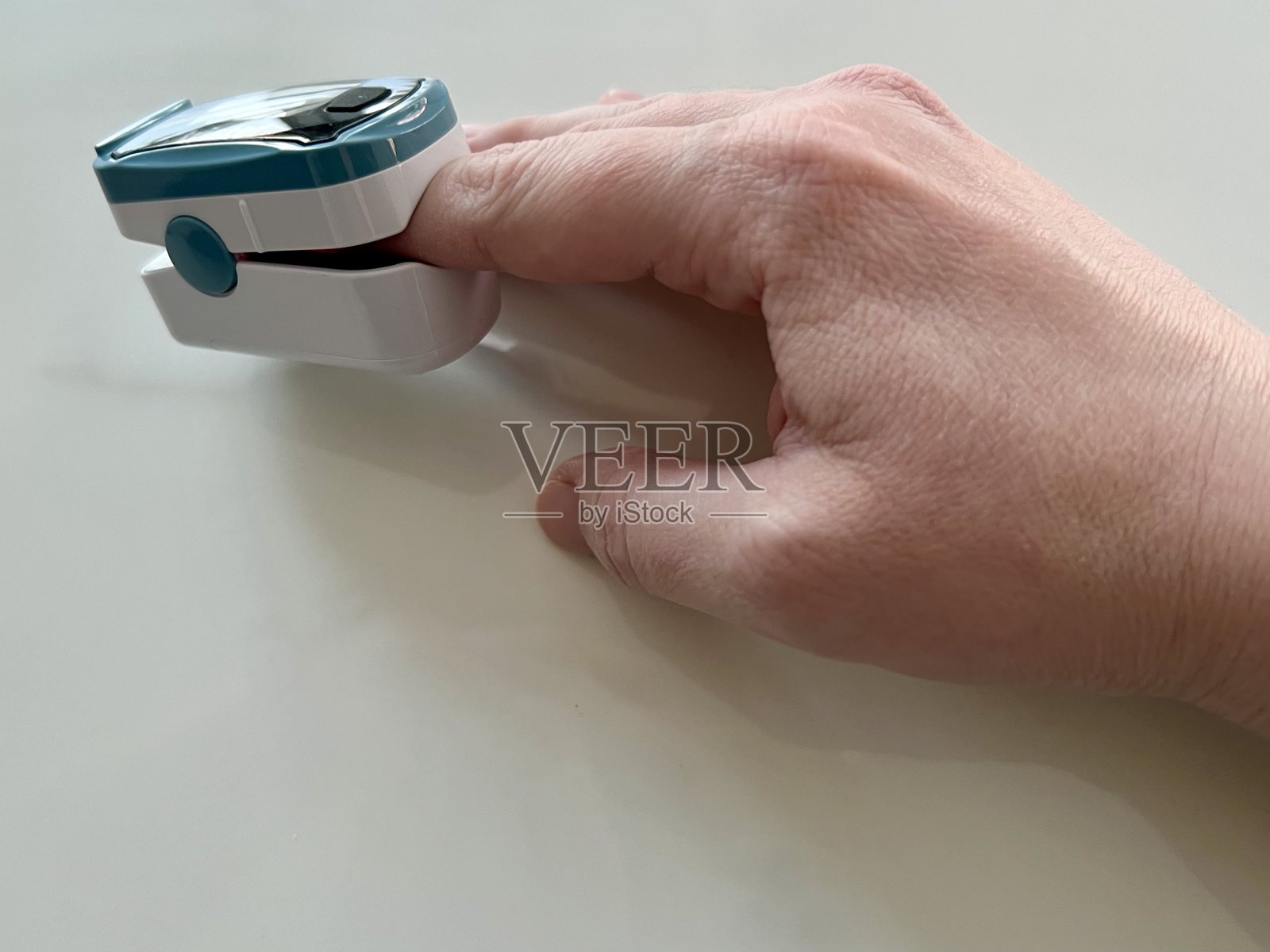 在家使用指夹式脉搏血氧仪的人照片摄影图片