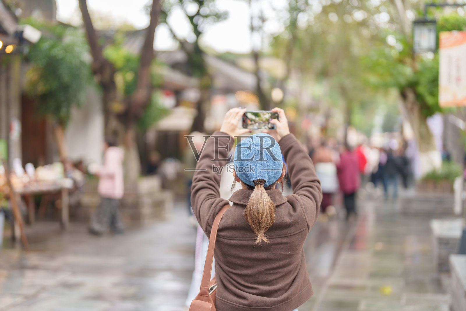 快乐的女游客在中国四川成都的宽窄巷子旅行，观光并拍照，这里是著名的旅游景点。照片摄影图片