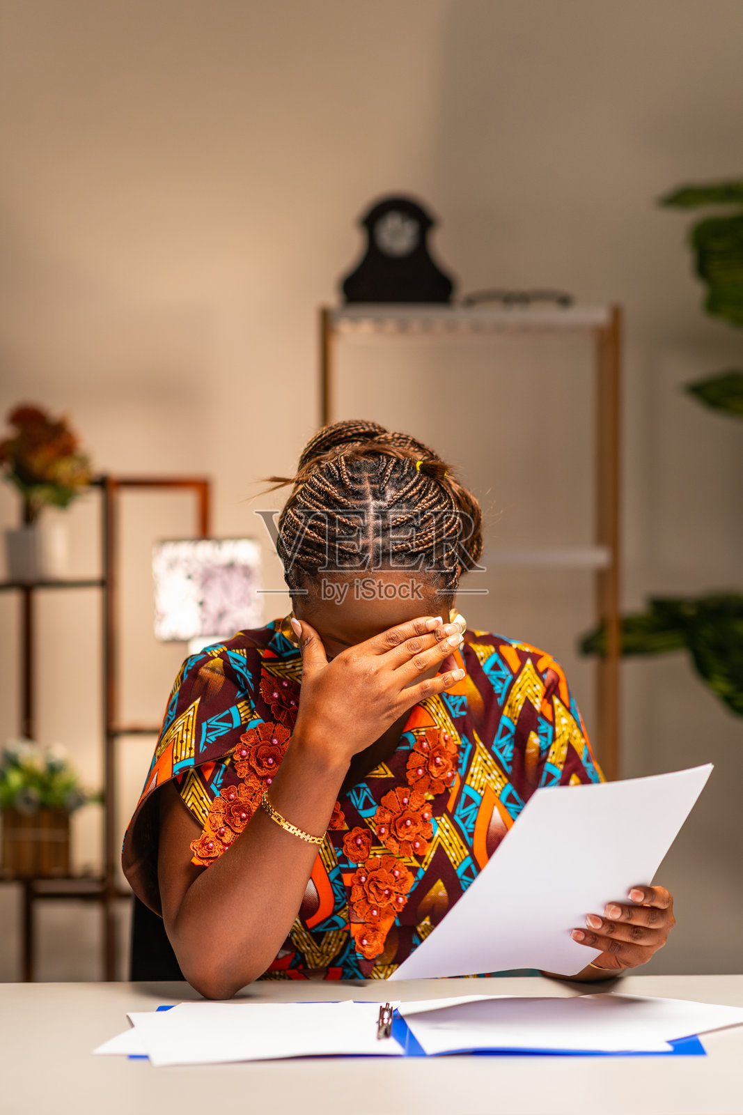 年轻的非洲女性在家中办公室，身负债务，查看账单、开支和税款照片摄影图片