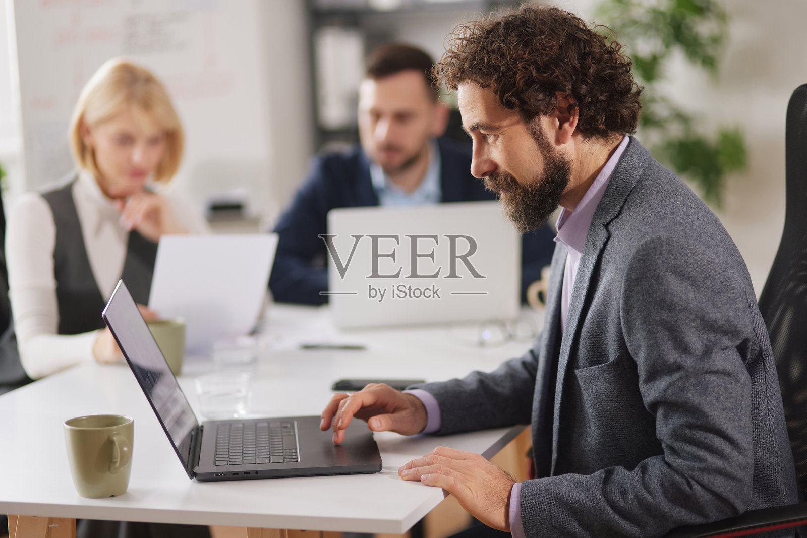 商务团队在现代办公室环境中进行头脑风暴会议，共同协作推进项目照片摄影图片