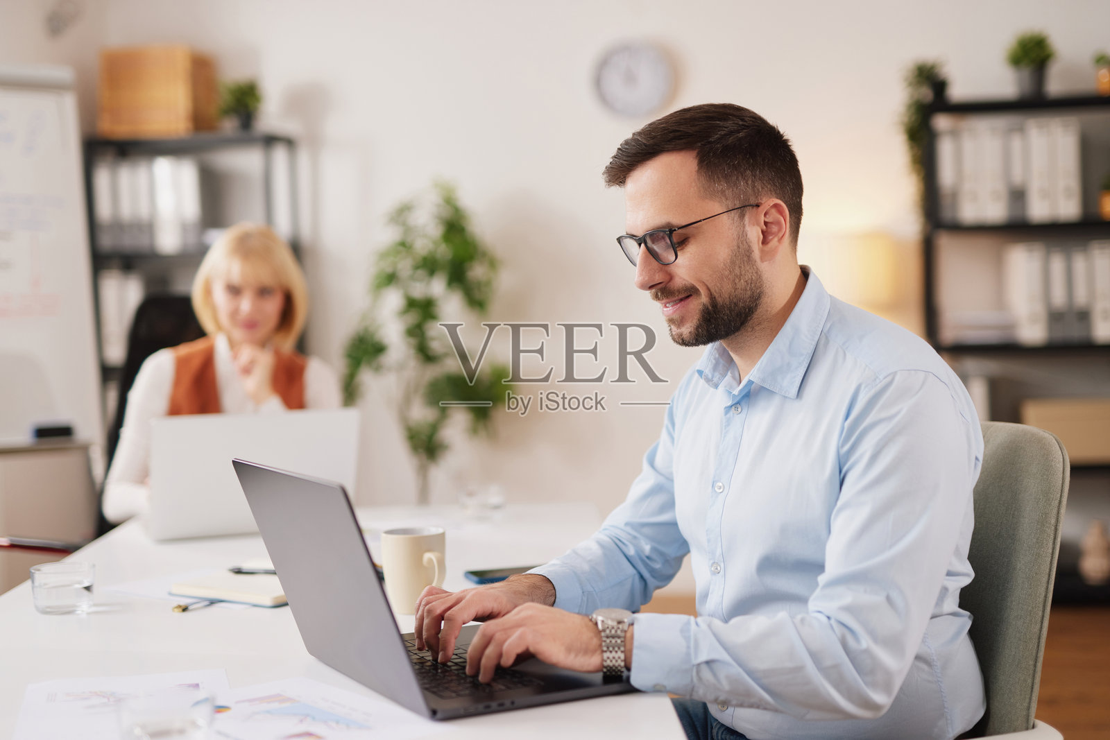 商务团队在现代办公室环境中，于上午时段进行专注的讨论和规划，共同协作项目。照片摄影图片