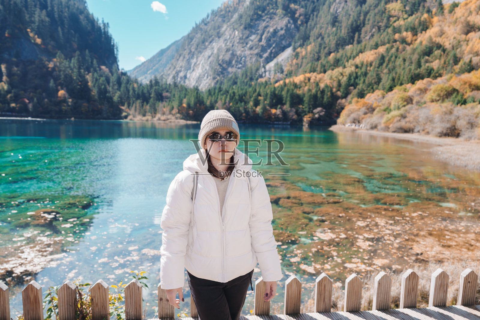 快乐的女游客在中国四川九寨沟国家公园旅行。游客在秋季游览五彩池和雪山。成都附近的著名地标和度假胜地。照片摄影图片