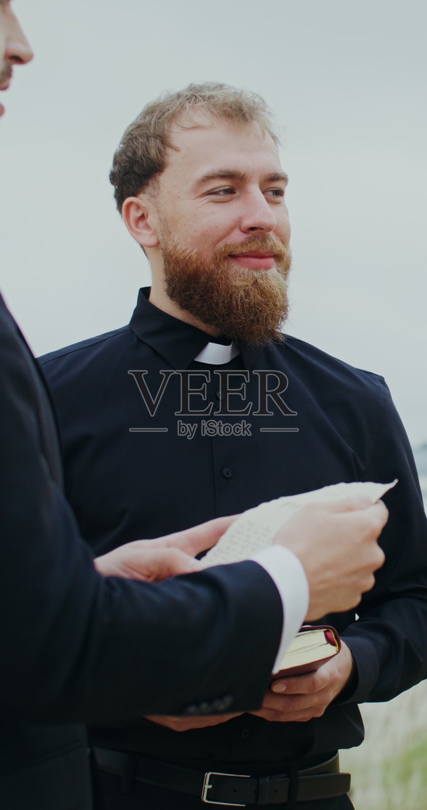 新郎在海边举行婚礼并朗读誓词。照片摄影图片