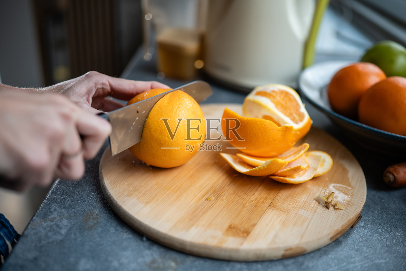 切板上切新鲜橙子的手照片摄影图片