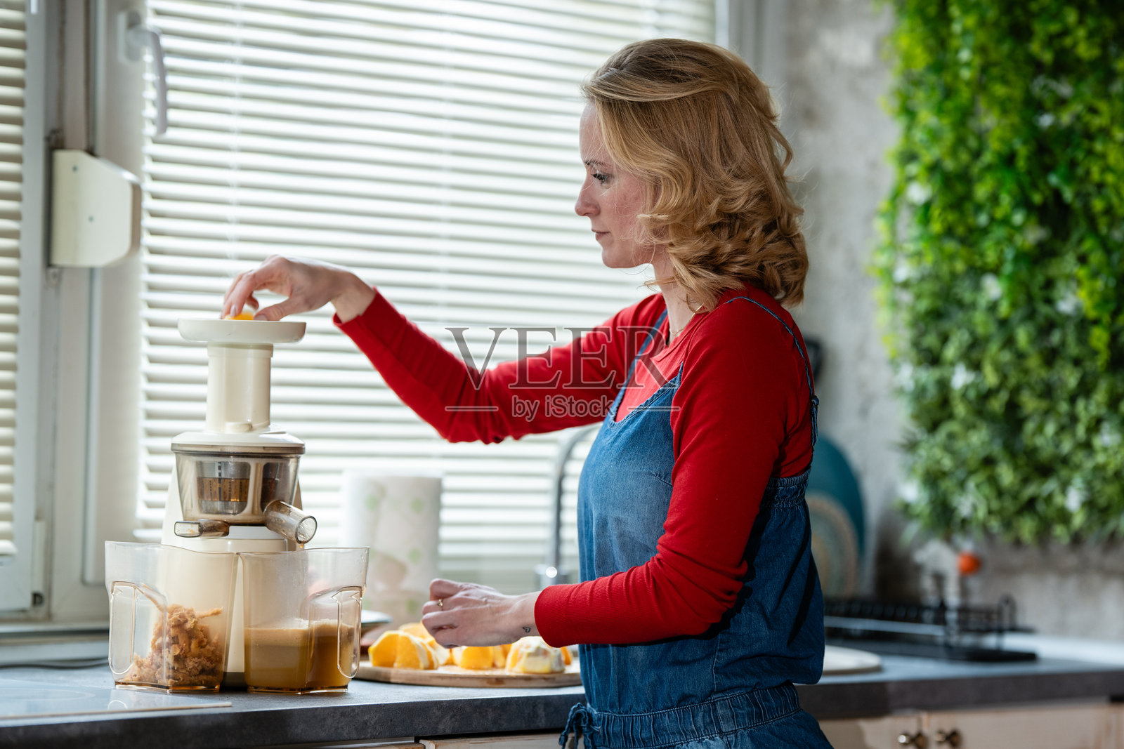 女子在厨房制作新鲜橙汁照片摄影图片