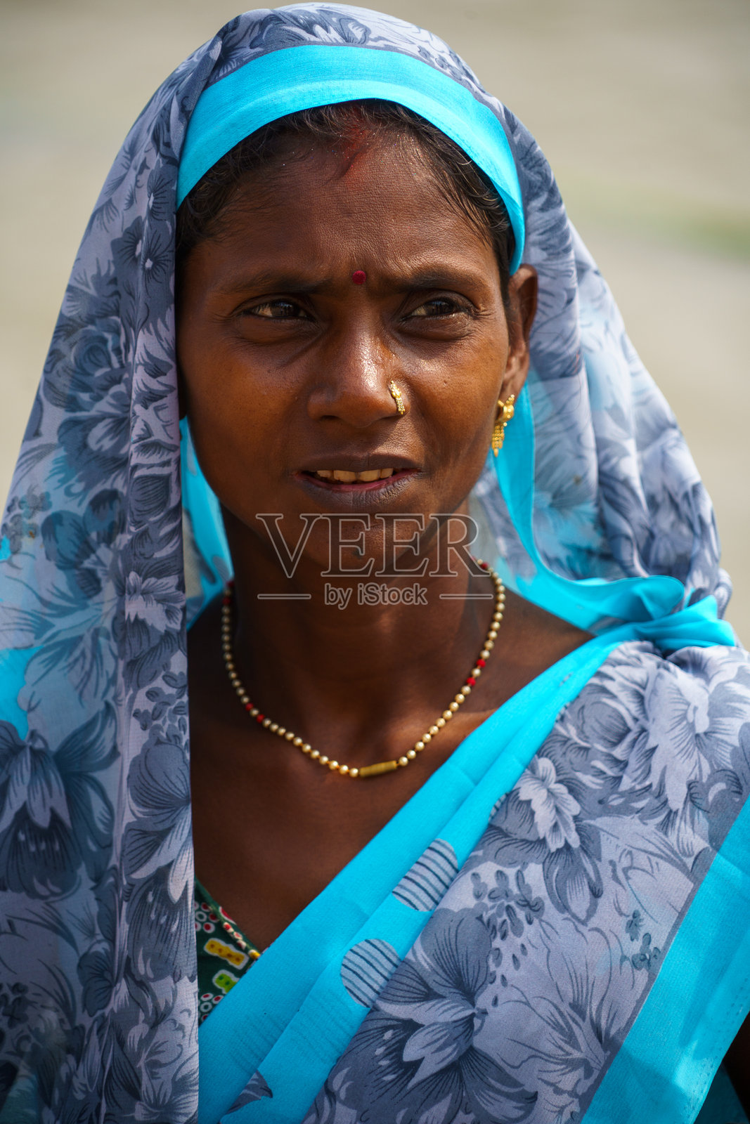 印度。北方邦。瓦拉纳西(贝拿勒斯)。身着鲜艳蓝灰纱丽的年轻女子肖像照片摄影图片