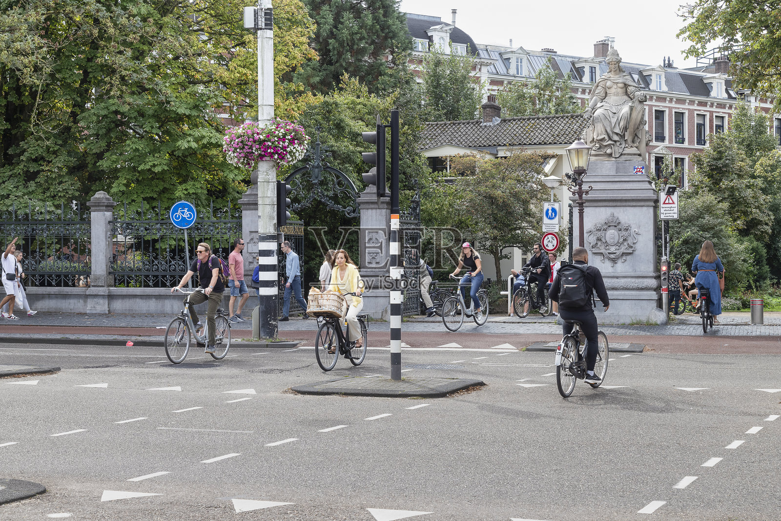 骑行者穿过繁忙的街道往返于阿姆斯特丹的冯德尔公园。照片摄影图片
