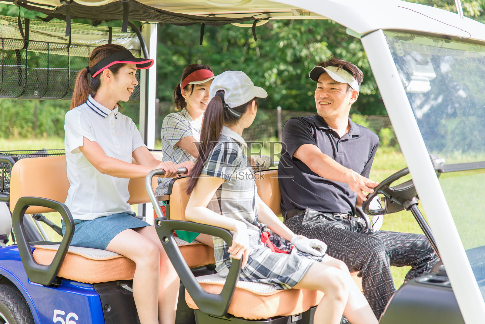 一对男女高尔夫球手在球场上乘坐高尔夫球车照片摄影图片