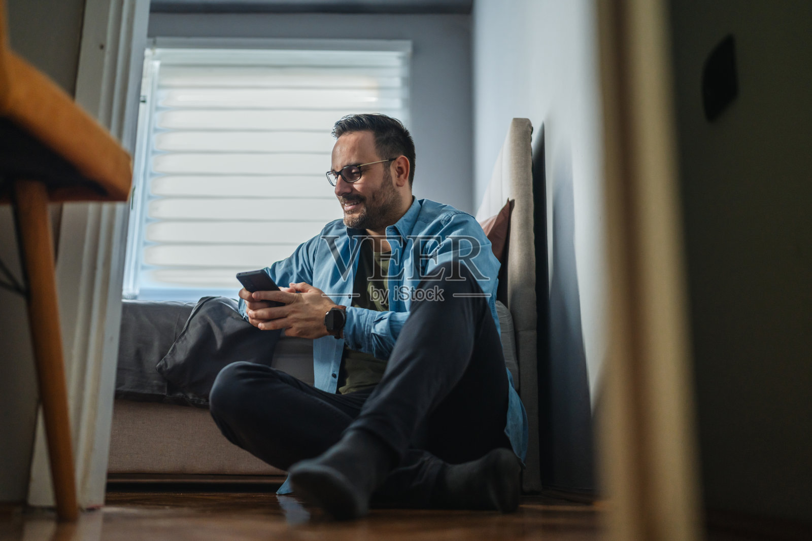男人在家使用智能手机进行社交媒体和通讯照片摄影图片