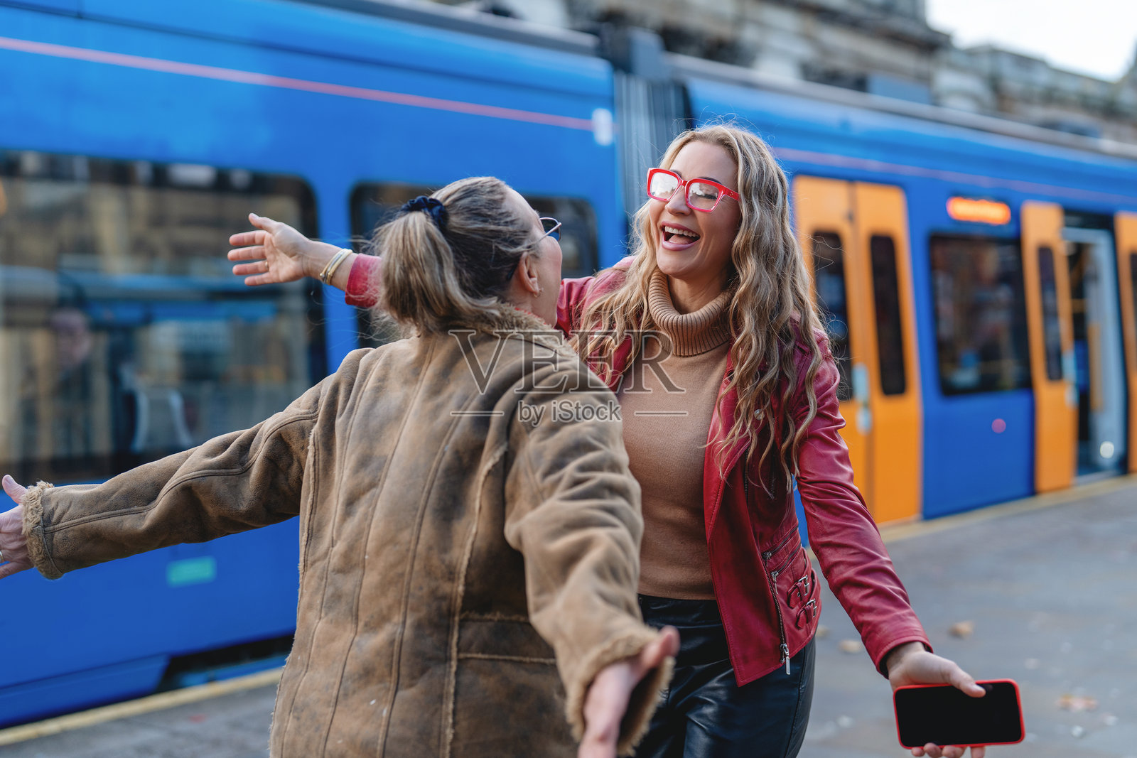下午，朋友们在热闹的城市火车站相聚照片摄影图片