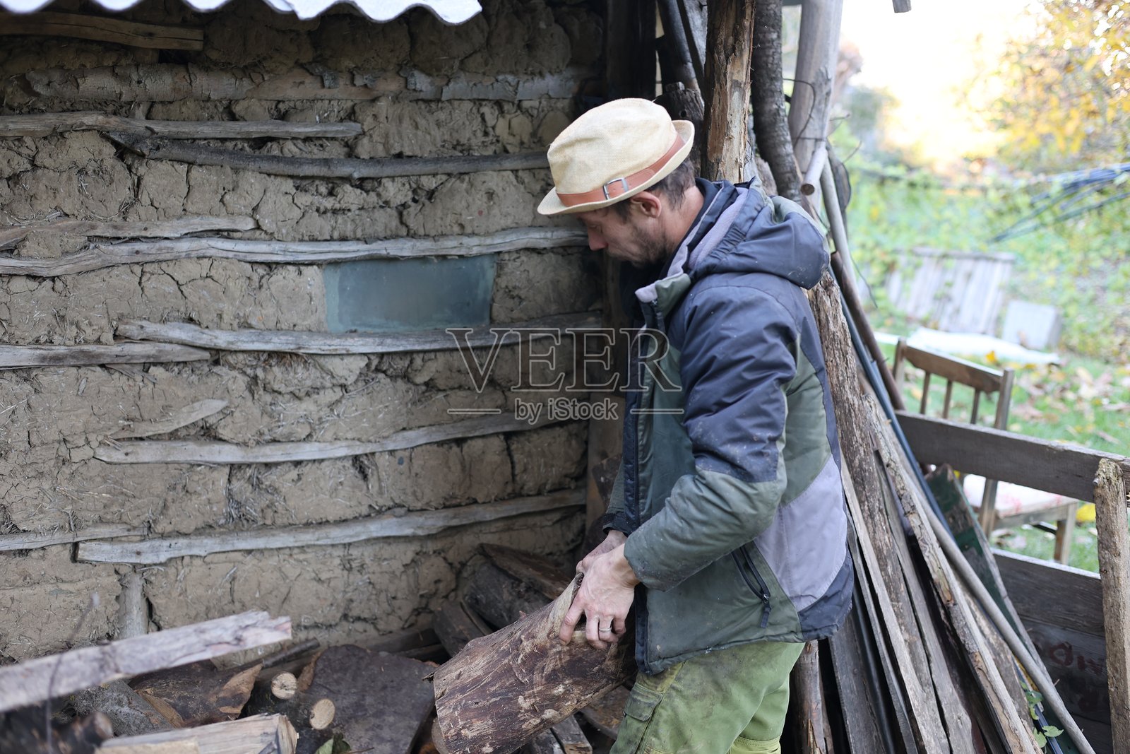 一位乡村男子正在自家花园里使用斧头进行木工活照片摄影图片