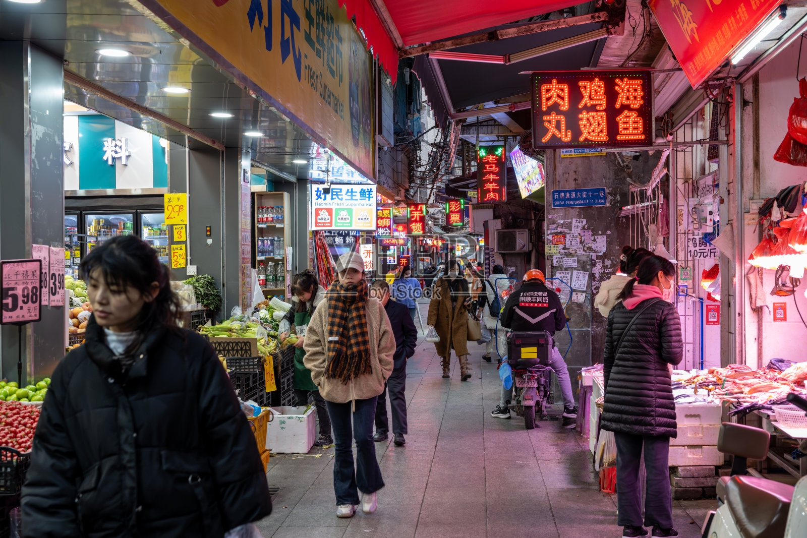 中国广州：熙熙攘攘的食品市场街道，有水果摊、海鲜摊贩、踏板车和霓虹灯。中国南方充满活力的城市日常生活。照片摄影图片