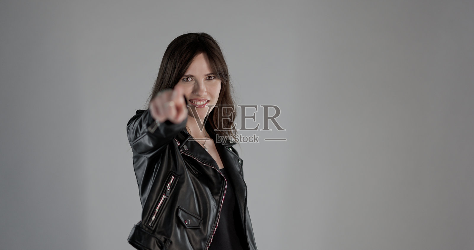 年轻女子对着镜头微笑并竖起食指照片摄影图片