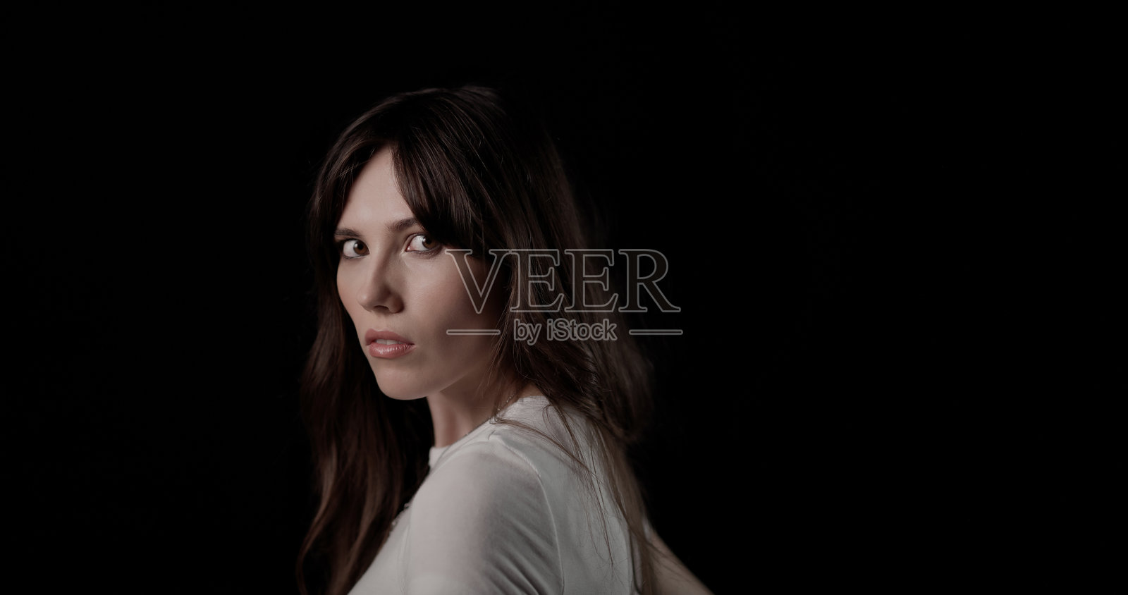 一位女子回眸，眼神专注照片摄影图片