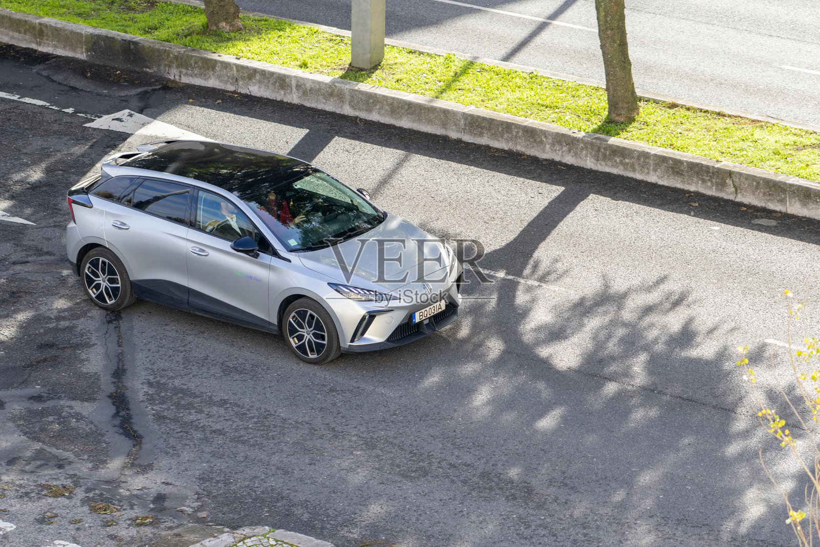 银色名爵MG4电动汽车在城市街道上行驶照片摄影图片