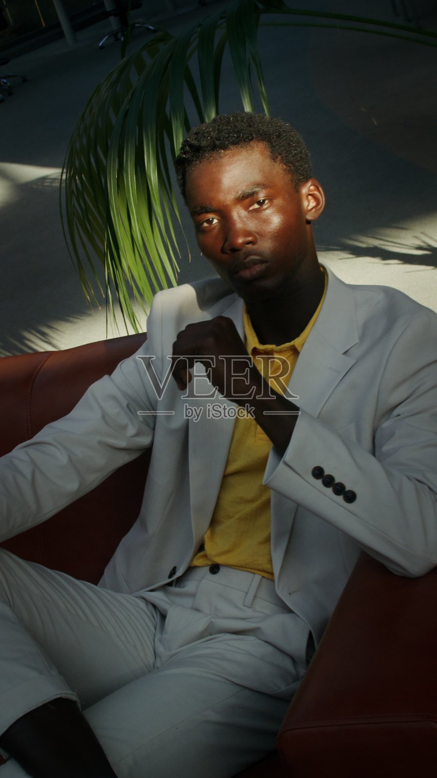 一个男人坐在沙发上。照片摄影图片